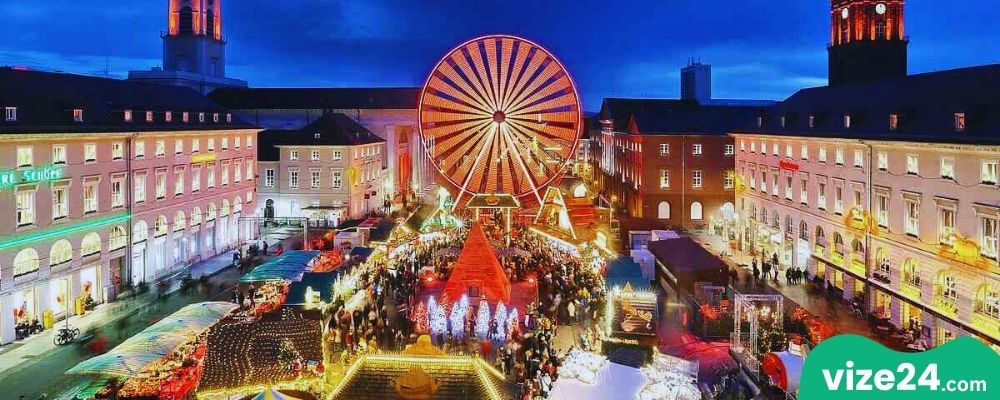 Karlsruhe Weihnachtsmarkt noel pazarı ışıklı stantlar ve kalabalık meydan